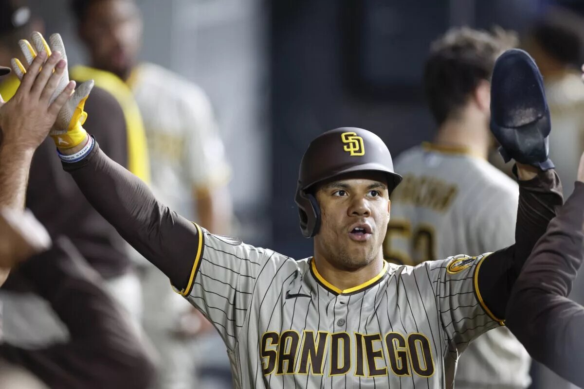 Padres left fielder Juan Soto (22) celebrates with teammates after scoring a run.