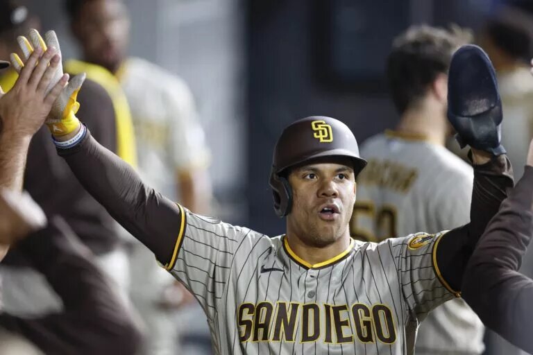 Padres left fielder Juan Soto (22) celebrates with teammates after scoring a run.
