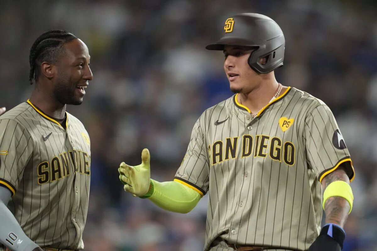 Padres third baseman Manny Machado (13) is greeted by left fielder Jurickson Profar (10) after scoring a run during the second inning against the Los Angeles Dodgers at Dodger Stadium in September 2024.