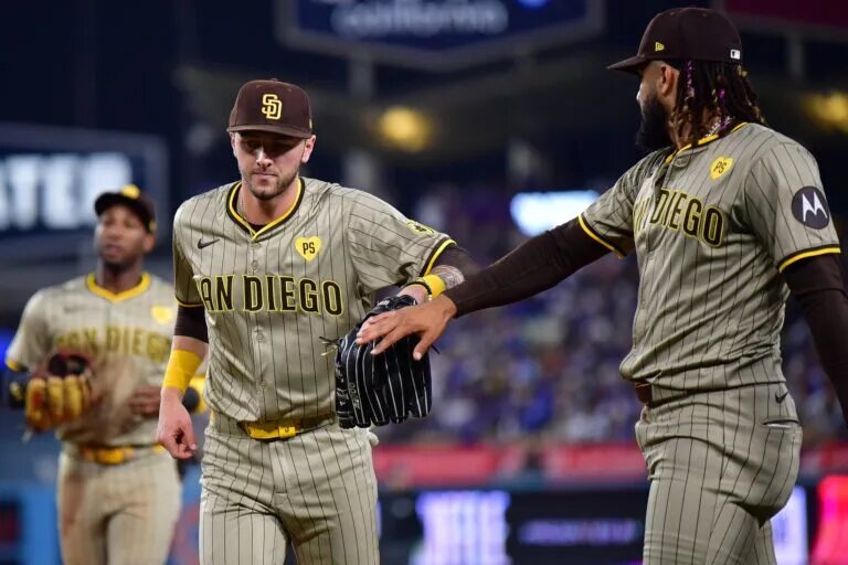 Padres center fielder Jackson Merrill (3) is greeted by right fielder Fernando Tatis Jr. (23) after catching a fly ball.
