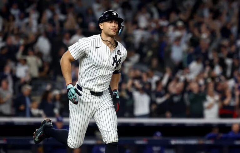 New York Yankees designated hitter Giancarlo Stanton (27) reacts after hitting a home run during the third inning against the Los Angeles Dodgers in game five of the 2024 World Series at Yankee Stadium.
