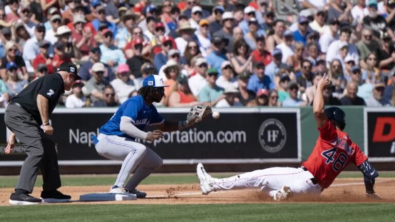 Blue Jays third baseman/prospect Charles McAdoo (84) just misses a tag during a 2025 spring training game.