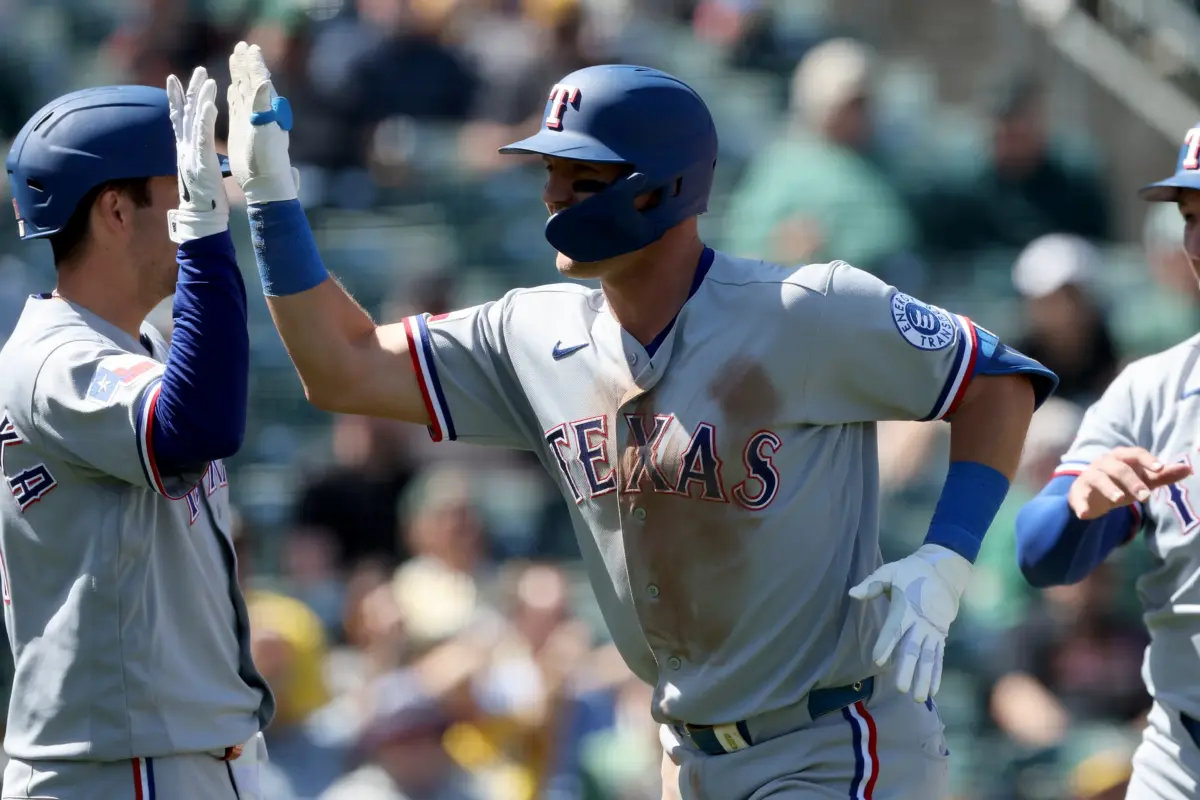 Texas Rangers third baseman Josh Jung celebrating with teammates after hitting a two-run home run against the Athletics on April 16, 2026.