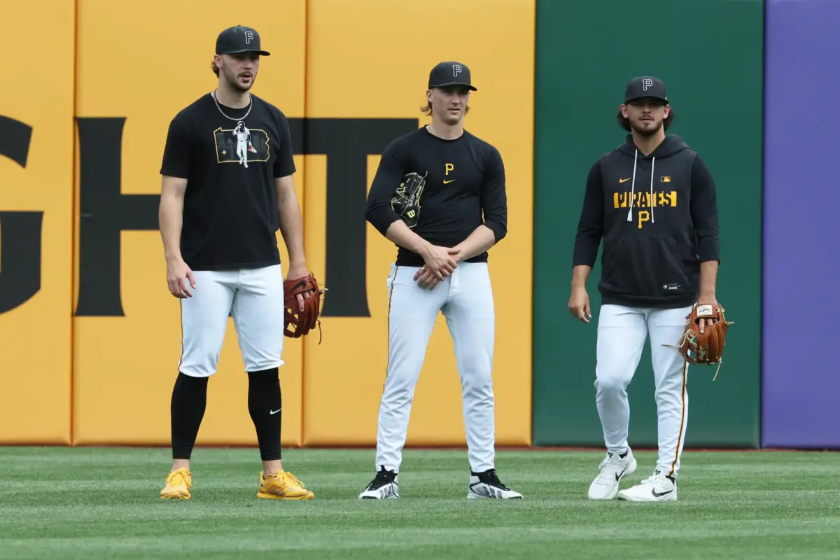 Pittsburgh Pirates starting pitchers Paul Skenes (left), Bubba Chandler (center), and Jared Jones (right) talking in the outfield before a game against the Philadelphia Phillies at PNC Park in Pittsburgh, Pennsylvania on May 15, 2026.