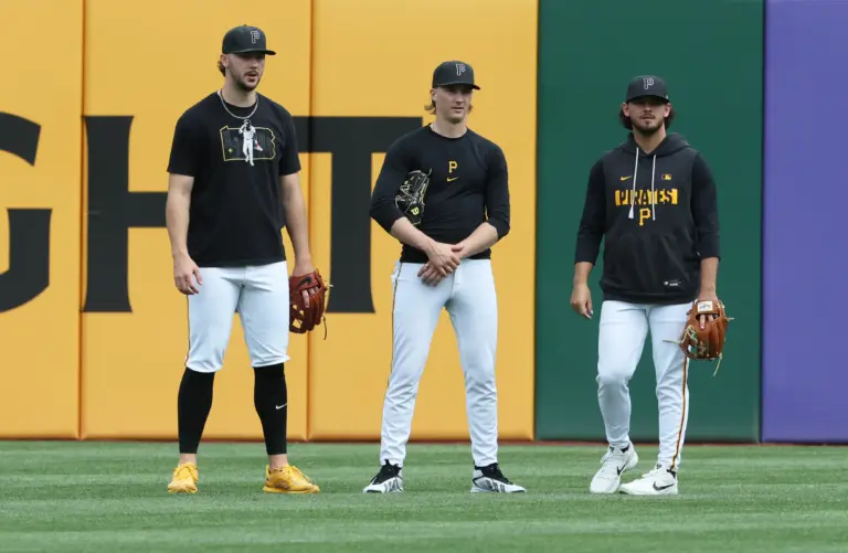 Pittsburgh Pirates starting pitchers Paul Skenes (left), Bubba Chandler (center), and Jared Jones (right) talking in the outfield before a game against the Philadelphia Phillies at PNC Park in Pittsburgh, Pennsylvania on May 15, 2026.