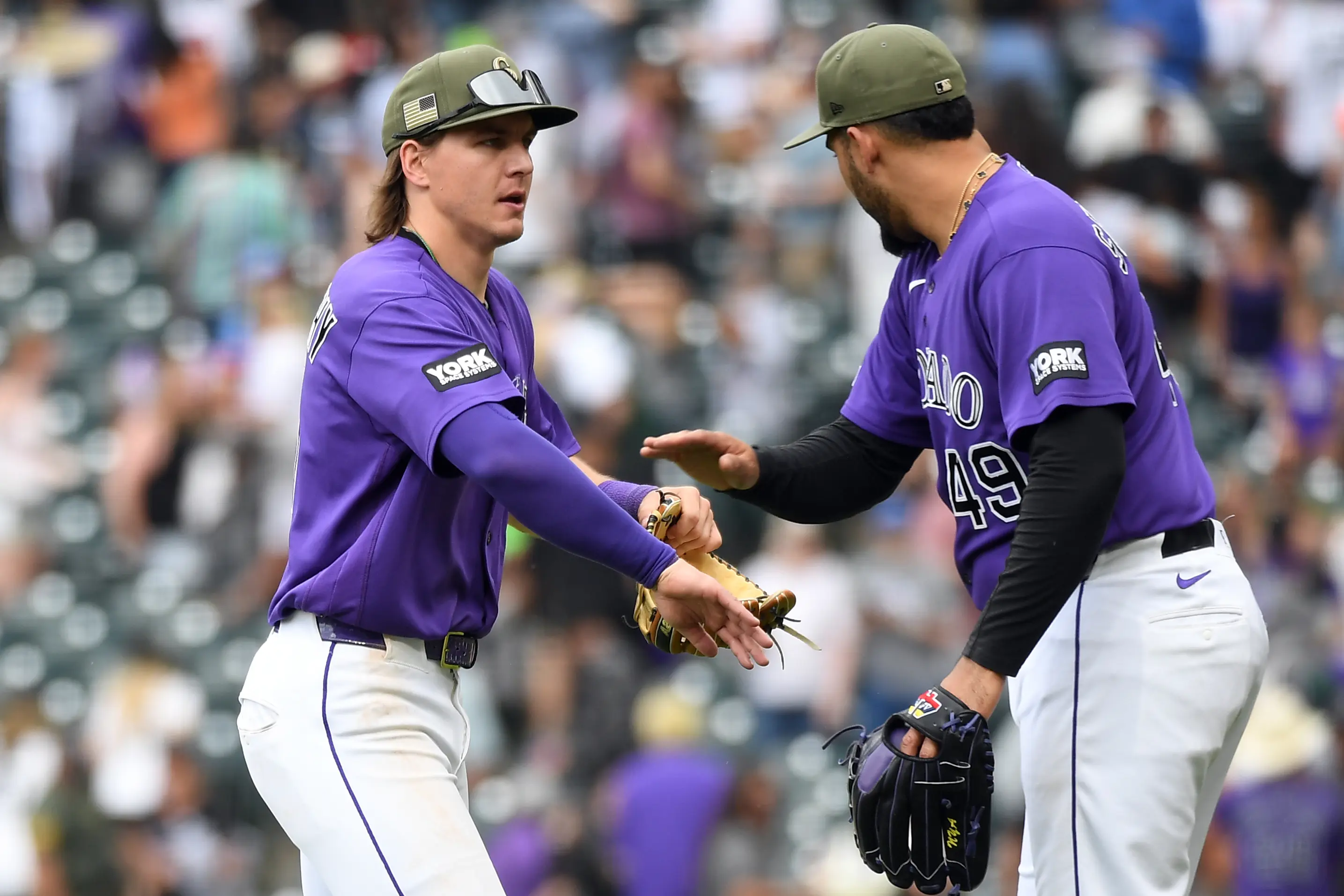 Rockies reliever Antonio Senzatela high-fiving teammate Jake McCarthy after clinching a save against the Arizona Diamondbacks at Coors Field in Denver, Colorado on May 16, 2026.