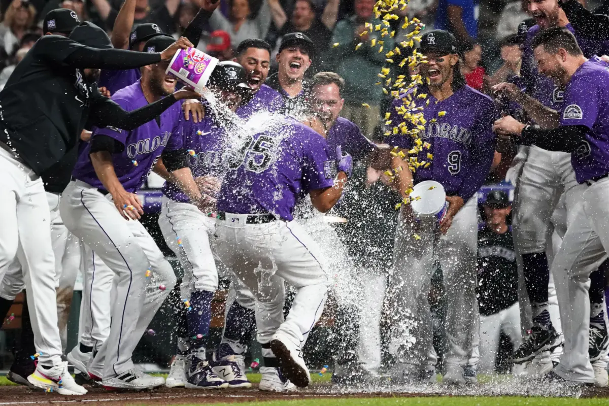Colorado Rockies catcher Elias Diaz is greeted at home plate by teammates after hitting a walk-off three run home run vs the Arizona Diamondbacks at Coors Field in Denver, Colorado on August 21, 2021.