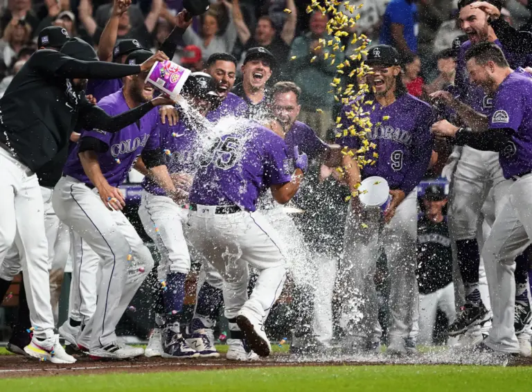 Colorado Rockies catcher Elias Diaz is greeted at home plate by teammates after hitting a walk-off three run home run vs the Arizona Diamondbacks at Coors Field in Denver, Colorado on August 21, 2021.