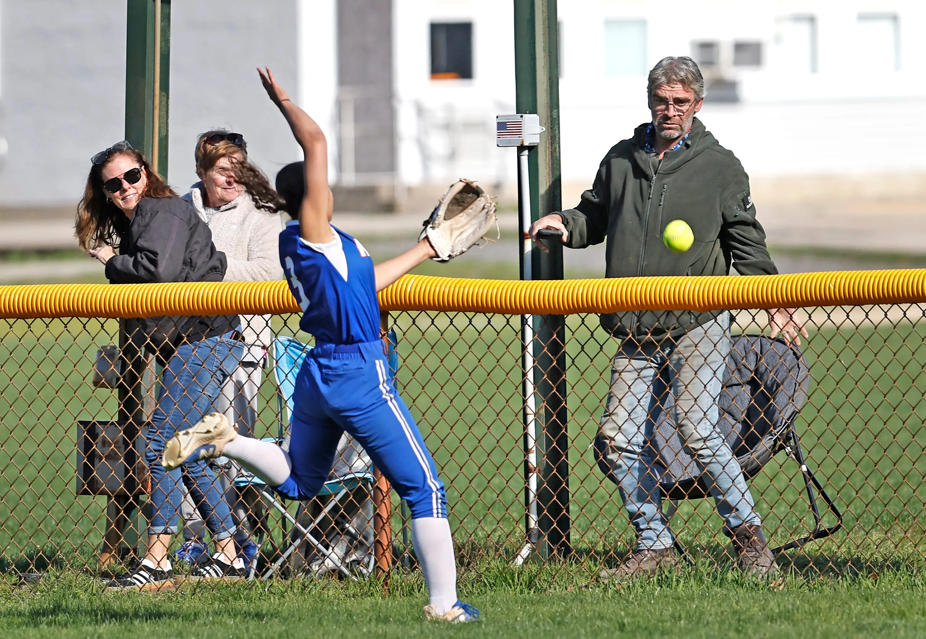 Hawks center fielder Olivia Stear runs to catch up to a long flyball that stayed in play after hitting the yellow padding on the fence for a Bishops double by Julie Murphy.