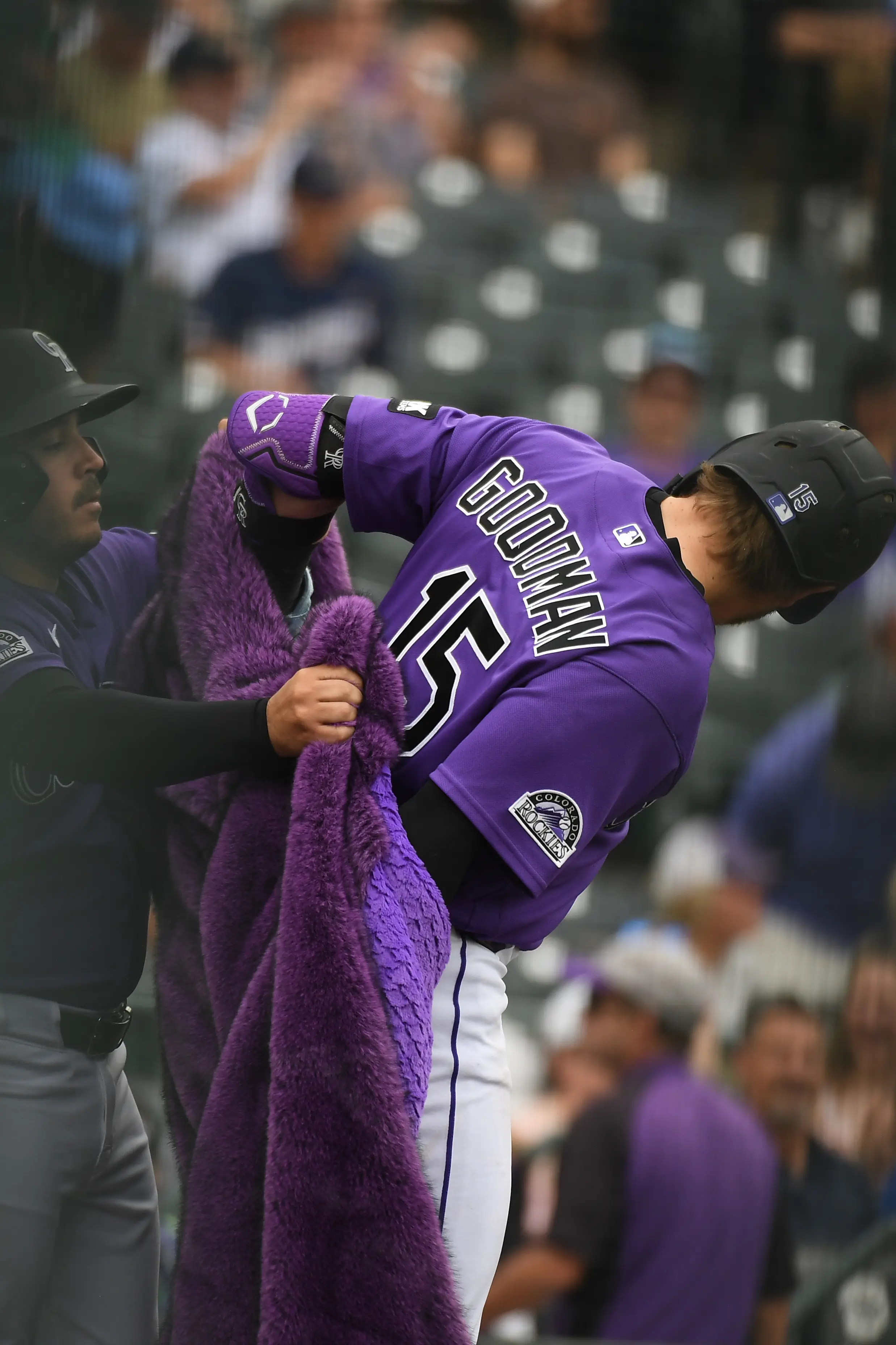 Colorado Rockies catcher Hunter Goodman putting on the celebratory shaggy purple coat after hitting a ninth-inning home run vs the Milwaukee Brewers at Coors Field in Denver, Colorado, on June 7, 2026.