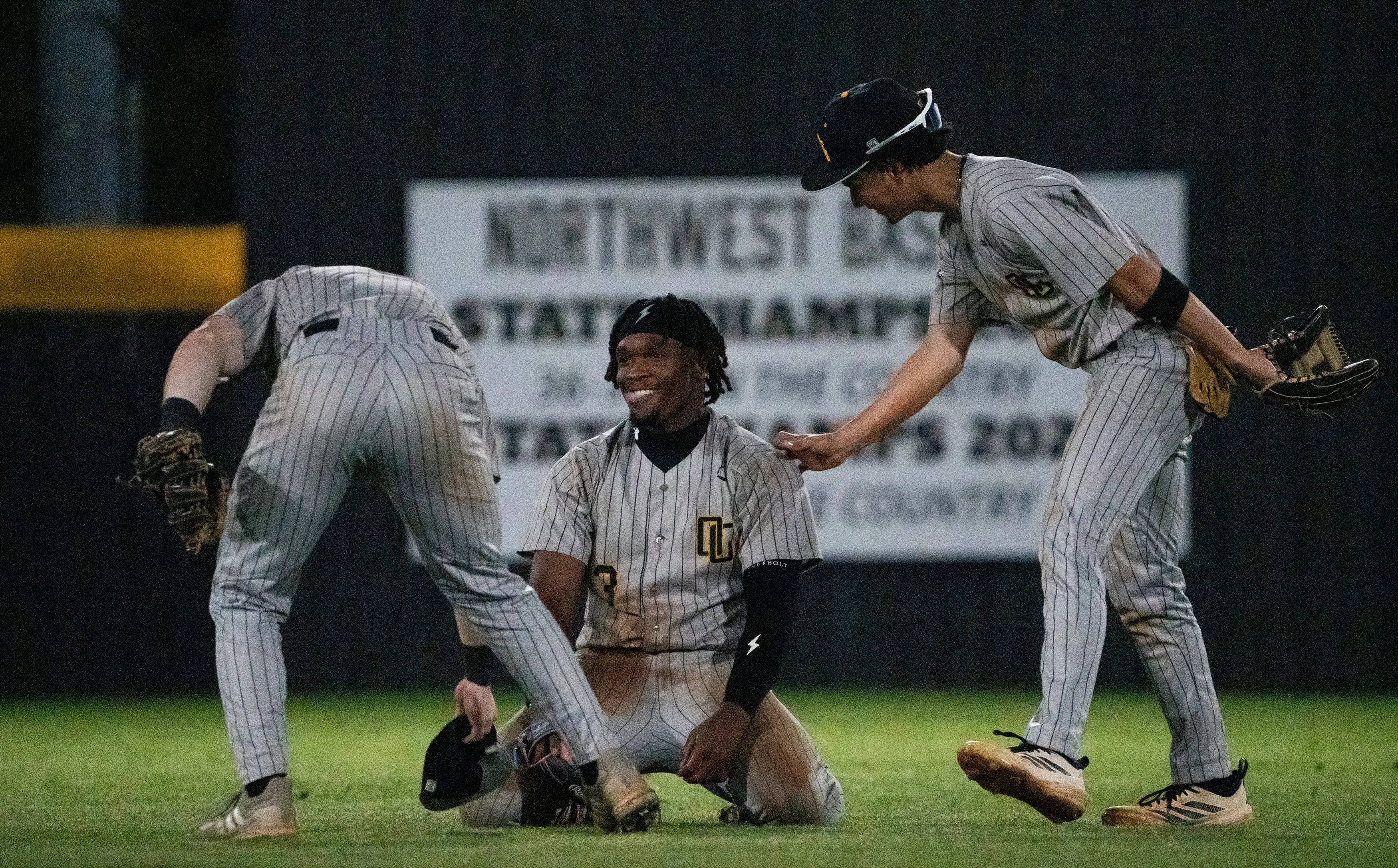 Oak Grove outfielder Eric 'EJ' Booth Jr. (3) is patted on the back after falling on the ground while catching a ball during the game against Northwest Rankin in Flowood, Miss., on Tuesday, March 24, 2026.