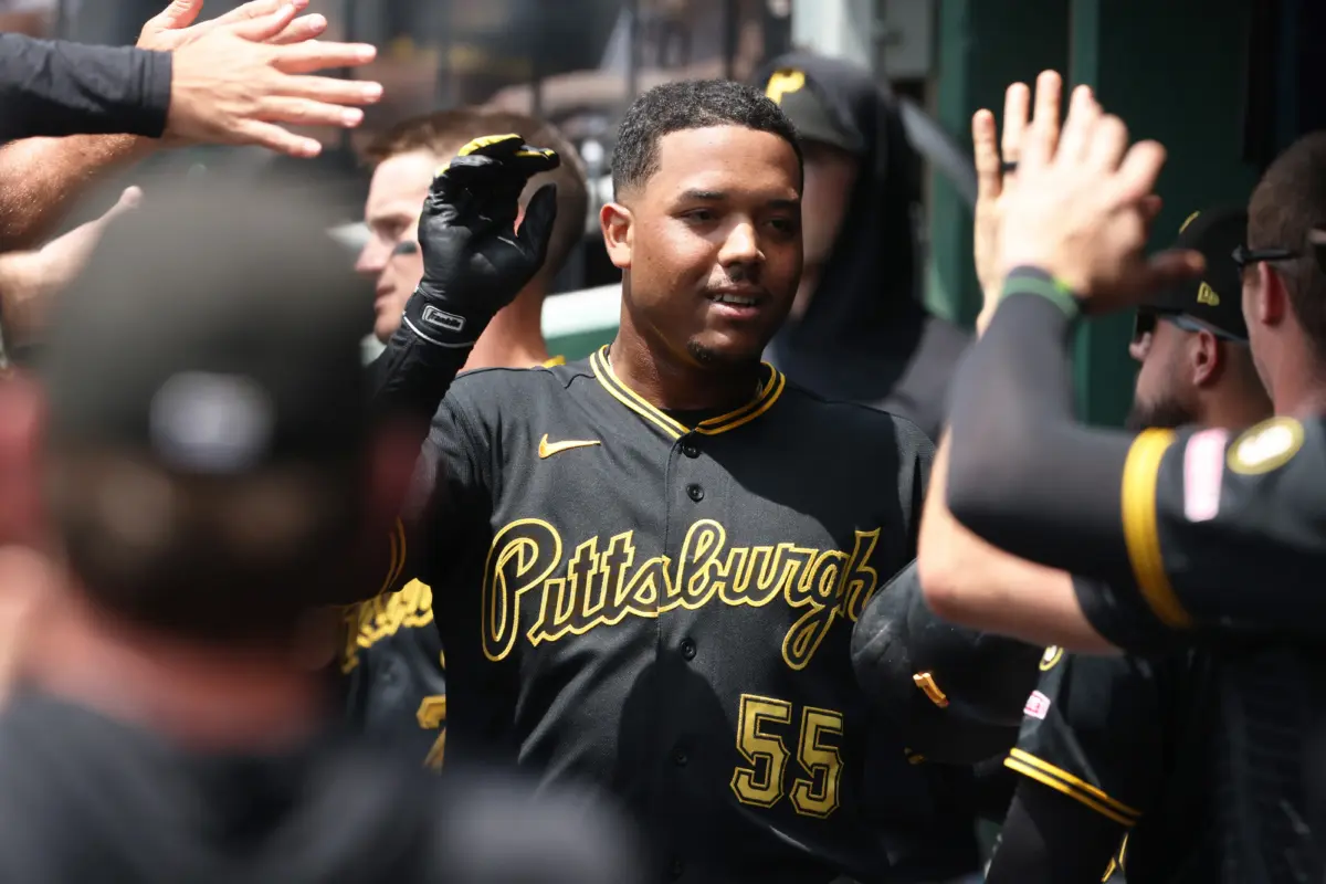 Pittsburgh Pirates right fielder Esmerlyn Valdez celebrating with teammates in dugout.