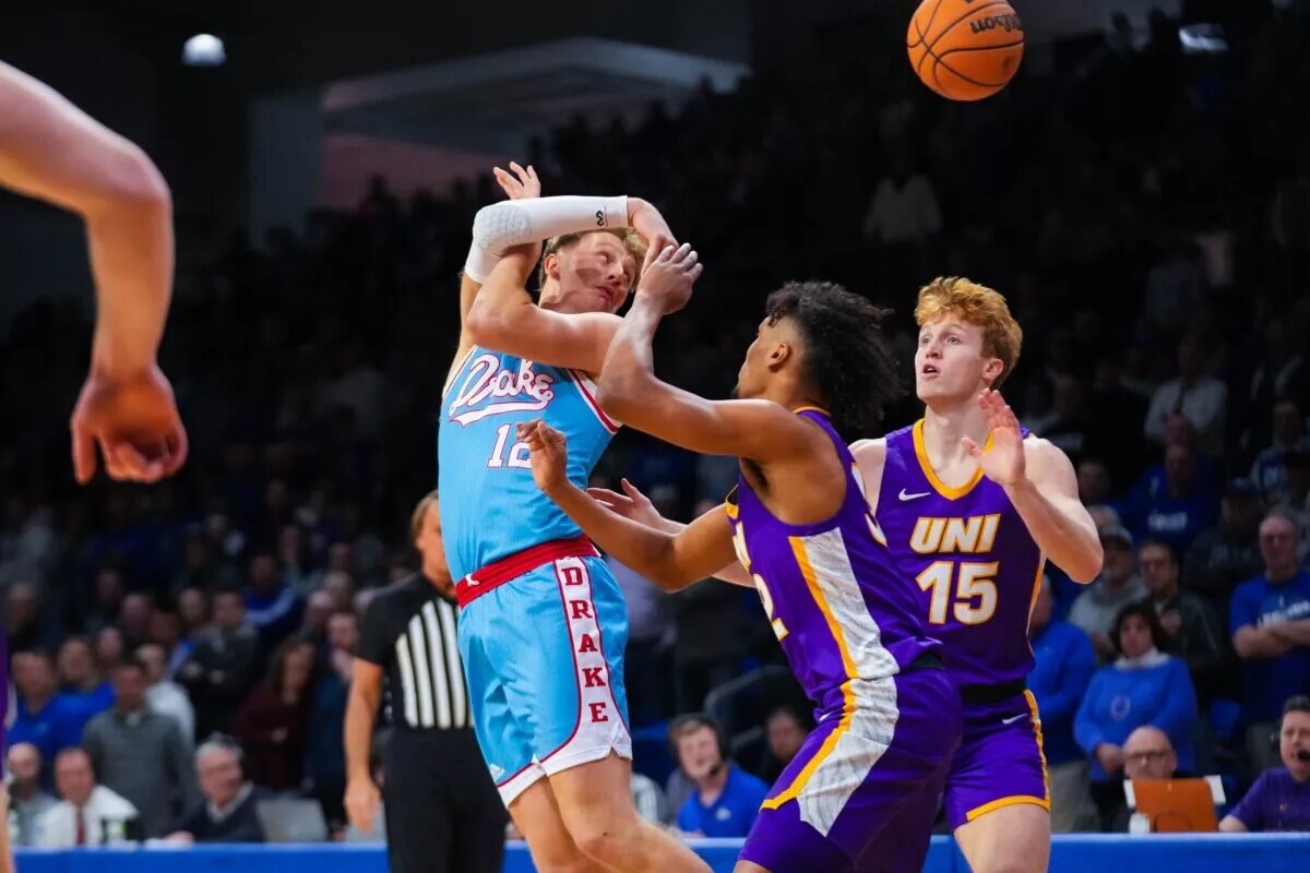 Drake forward Tucker DeVries (12) passes the ball over his back against UNI forward Tytan Anderson (32) during the game at Knapp Center on Wednesday, Feb. 1, 2023.