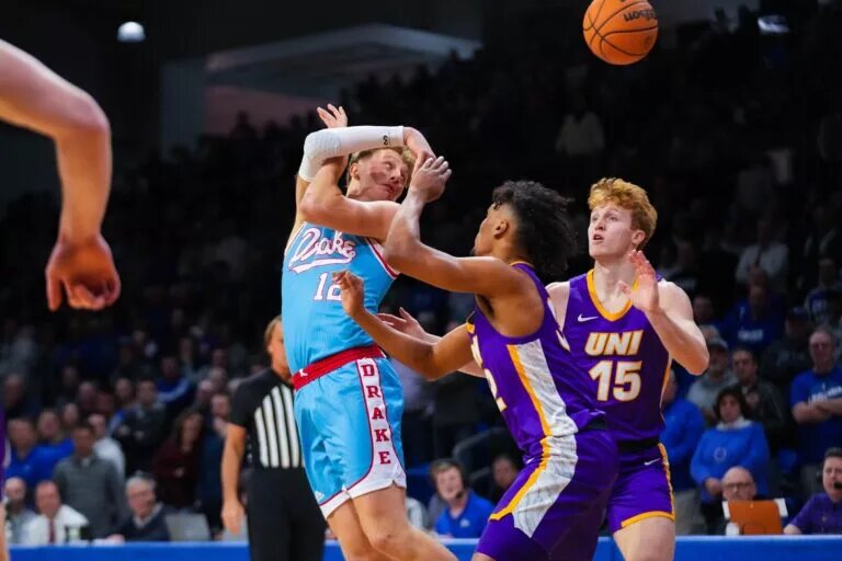 Drake forward Tucker DeVries (12) passes the ball over his back against UNI forward Tytan Anderson (32) during the game at Knapp Center on Wednesday, Feb. 1, 2023.