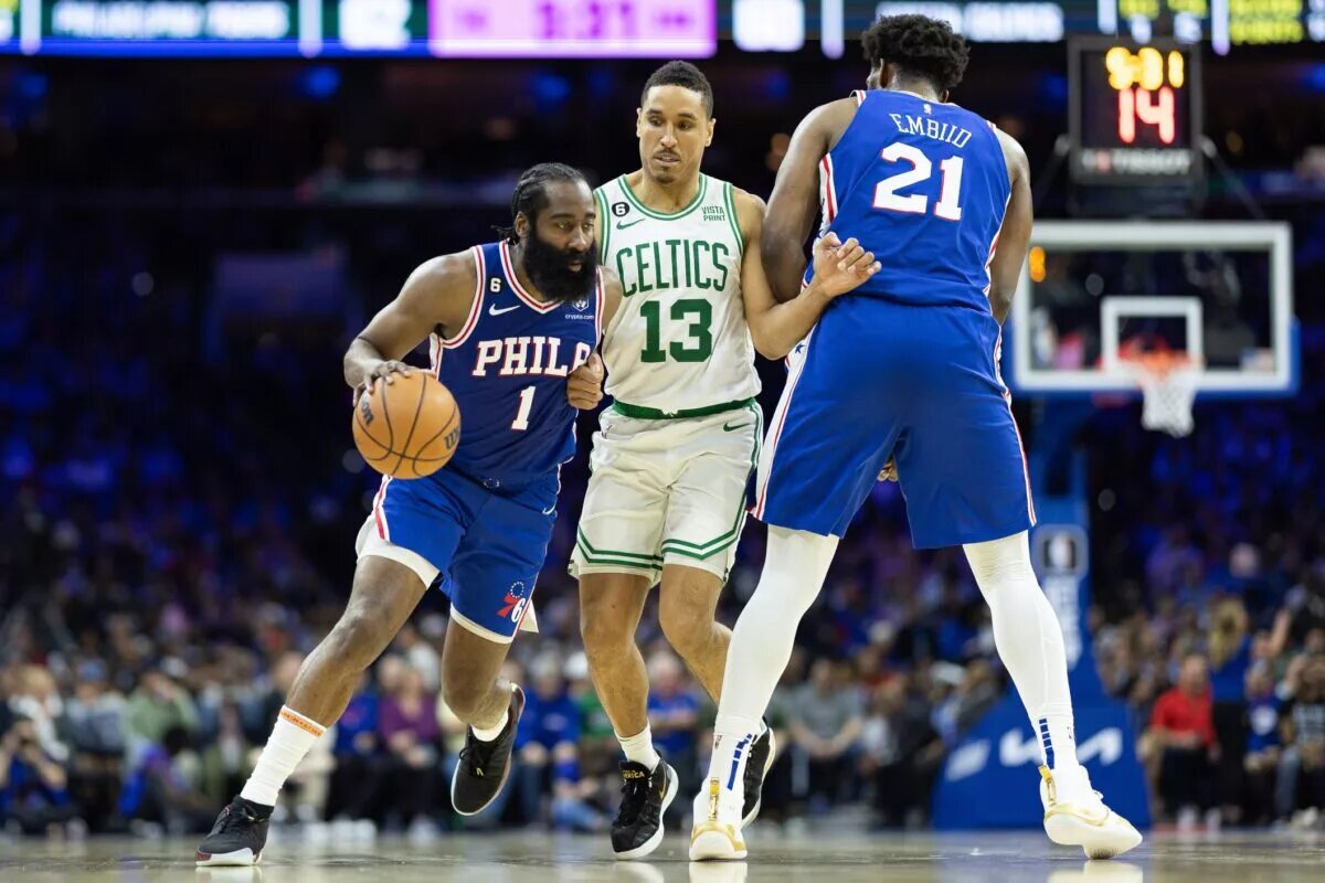 Apr 4, 2023; Philadelphia, Pennsylvania, USA; Philadelphia 76ers guard James Harden (1) drives past Boston Celtics guard Malcolm Brogdon (13) in front of center Joel Embiid (21) during the third quarter at Wells Fargo Center. Mandatory Credit: Bill Streicher-USA TODAY Sports