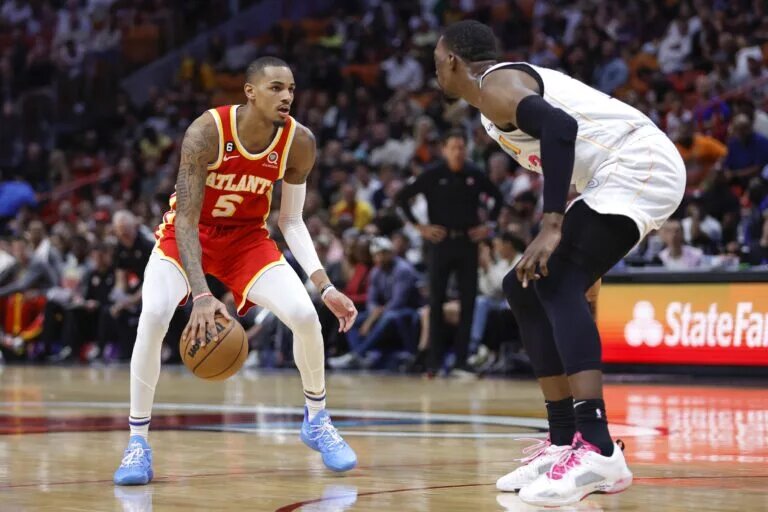 Mar 6, 2023; Miami, Florida, USA; Atlanta Hawks guard Dejounte Murray (5) dribbles the basketball as Miami Heat center Bam Adebayo (13) defends during the fourth quarter at Miami-Dade Arena. Mandatory Credit: Sam Navarro-USA TODAY Sports