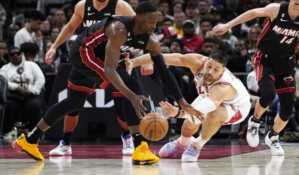 Mar 18, 2023; Chicago, Illinois, USA; Miami Heat center Bam Adebayo (left) and Chicago Bulls center Nikola Vucevic (9) go for the ball during the second half at United Center. Mandatory Credit: David Banks-USA TODAY Sports
