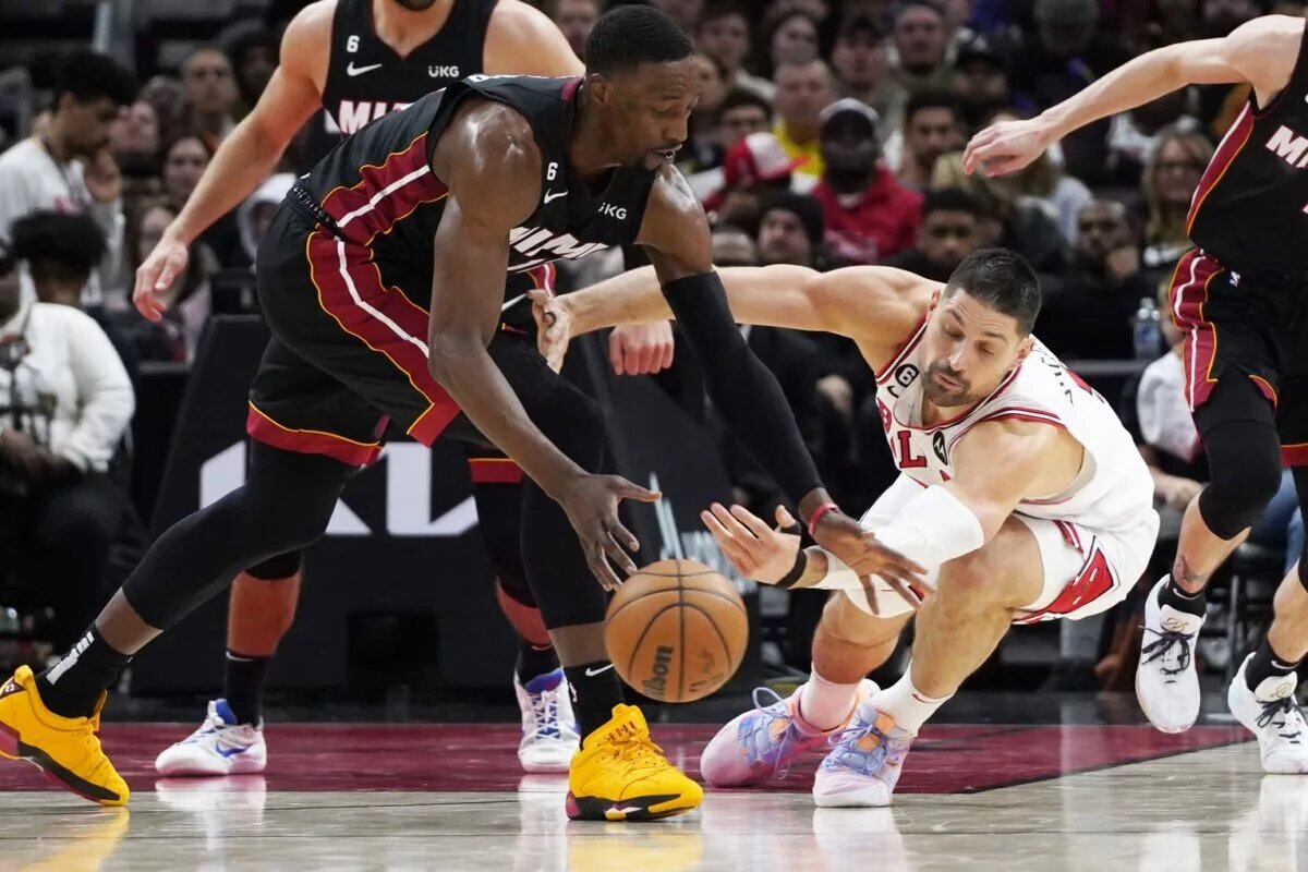 Mar 18, 2023; Chicago, Illinois, USA; Miami Heat center Bam Adebayo (left) and Chicago Bulls center Nikola Vucevic (9) go for the ball during the second half at United Center. Mandatory Credit: David Banks-USA TODAY Sports