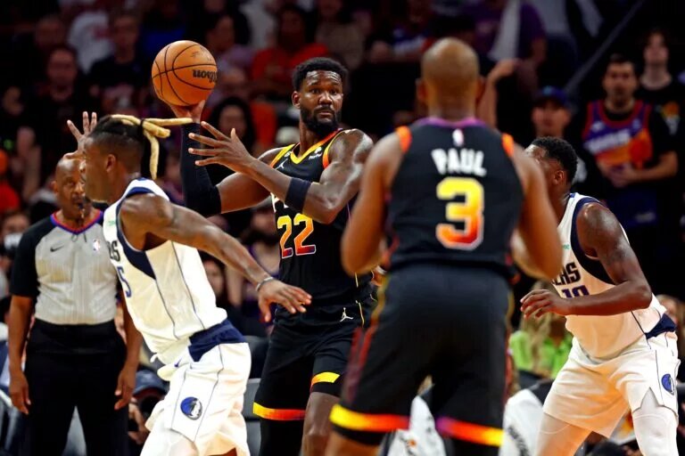 Oct 19, 2022; Phoenix, Arizona, USA; Phoenix Suns center Deandre Ayton (22) passes the ball to guard Chris Paul (3) against Dallas Mavericks forward Reggie Bullock (25) during the third quarter at Footprint Center. Mandatory Credit: Mark J. Rebilas-USA TODAY Sports