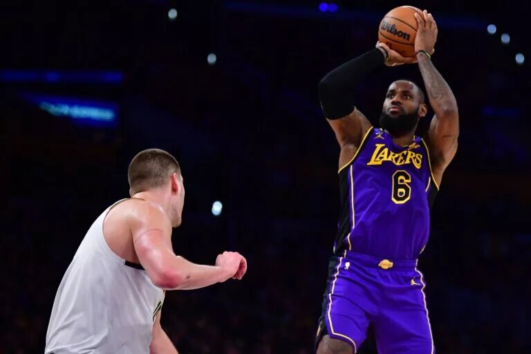 Dec 16, 2022; Los Angeles, California, USA; Los Angeles Lakers forward LeBron James (6) shoots against Denver Nuggets center Nikola Jokic (15) during the second half at Crypto.com Arena. Mandatory Credit: Gary A. Vasquez-USA TODAY Sports