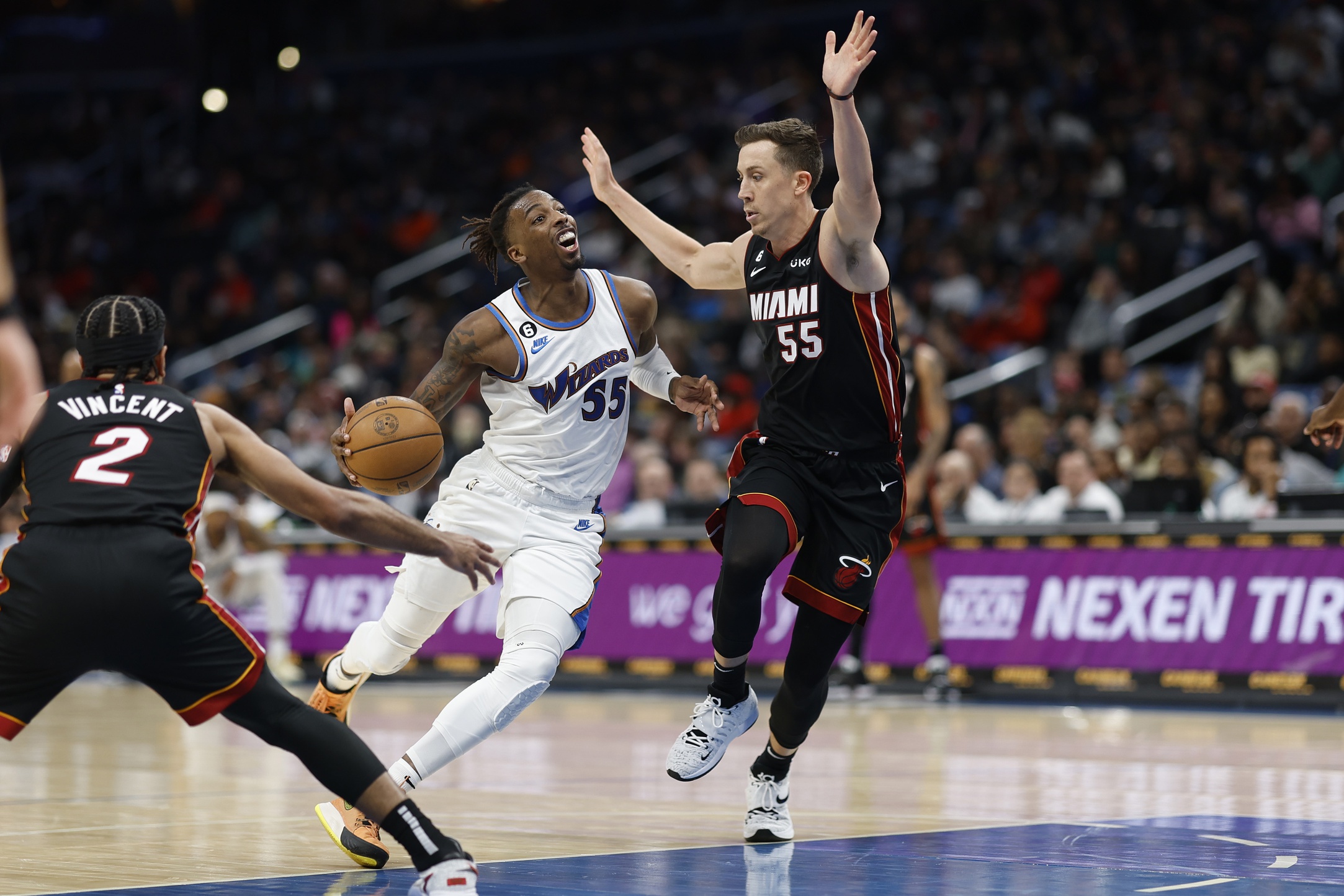 Apr 7, 2023; Washington, District of Columbia, USA; Washington Wizards guard Delon Wright (55) drives to the basket as Miami Heat forward Duncan Robinson (55) and Heat guard Gabe Vincent (2) defend in the third quarter at Capital One Arena. Mandatory Credit: Geoff Burke-USA TODAY Sports