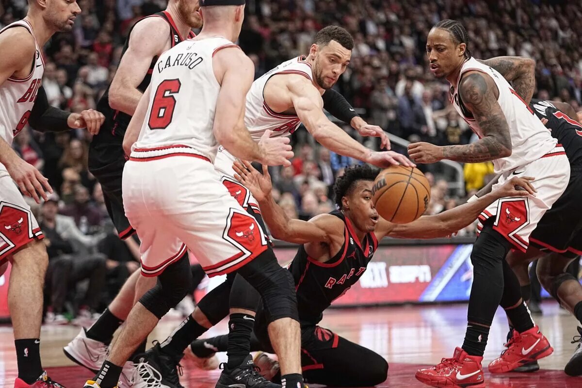 Apr 12, 2023; Toronto, Ontario, CAN; Chicago Bulls guard Zach LaVine (8) knocks the ball away from Toronto Raptors forward Scottie Barnes (4) as Chicago Bulls forward DeMar DeRozan (11) looks on during the second half of a NBA Play-In game at Scotiabank Arena. Mandatory Credit: John E. Sokolowski-USA TODAY Sports