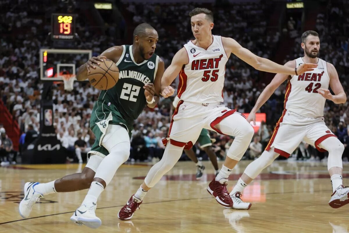 Apr 22, 2023; Miami, Florida, USA; Milwaukee Bucks forward Khris Middleton (22) drives to the basket against Miami Heat forward Duncan Robinson (55) in the second quarter during game three of the 2023 NBA Playoffs at Kaseya Center. Is Middleton's NBA contract one of the worst in the Eastern Conference? Mandatory Credit: Sam Navarro-USA TODAY Sports
