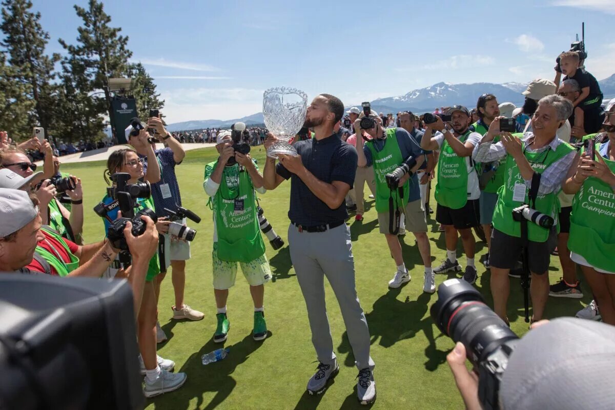 Stephen Curry celebrates kissing the trophy after sinking the winning putt during the final round of the American Century Celebrity Championship golf tournament at Edgewood Tahoe Golf Course in Stateline, Nev., Sunday, July 16, 2023.