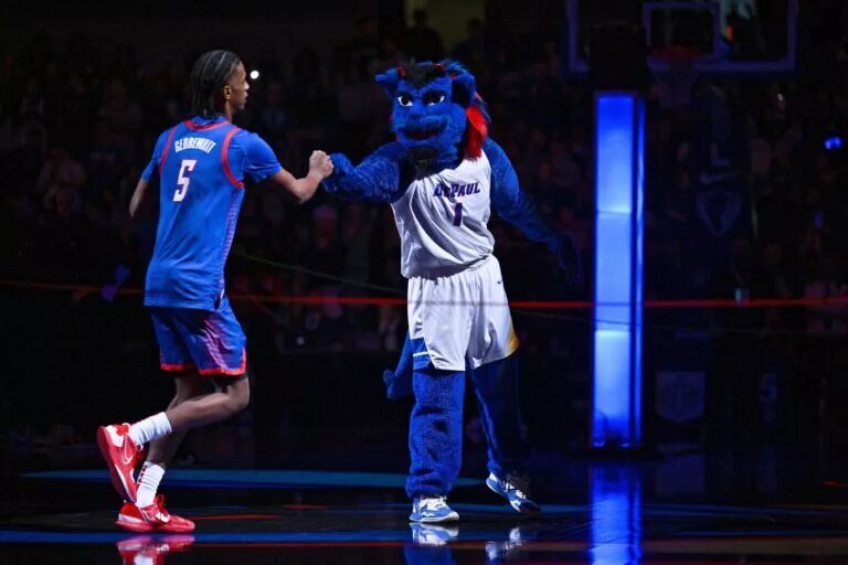 Jan 28, 2023; Chicago, Illinois, USA; The DePaul Blue Demon mascot fist bumps DePaul Blue Demons guard Philmon Gebrewhit (5) as he takes the court before a game against the Marquette Golden Eagles at Wintrust Arena. Mandatory Credit: Jamie Sabau-USA TODAY Sports