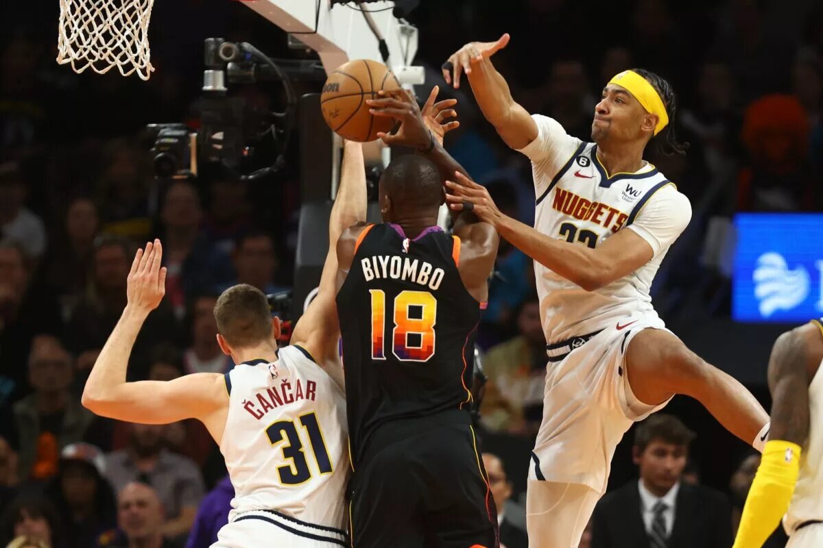 Apr 6, 2023; Phoenix, Arizona, USA; Phoenix Suns center Bismack Biyombo (18) drives to the basket under pressure from Denver Nuggets forward Zeke Nnaji (22) and Vlatko Cancar (31) in the second half at Footprint Center. Mandatory Credit: Mark J. Rebilas-USA TODAY Sports. Bismack is a potential target for the LA Lakers
