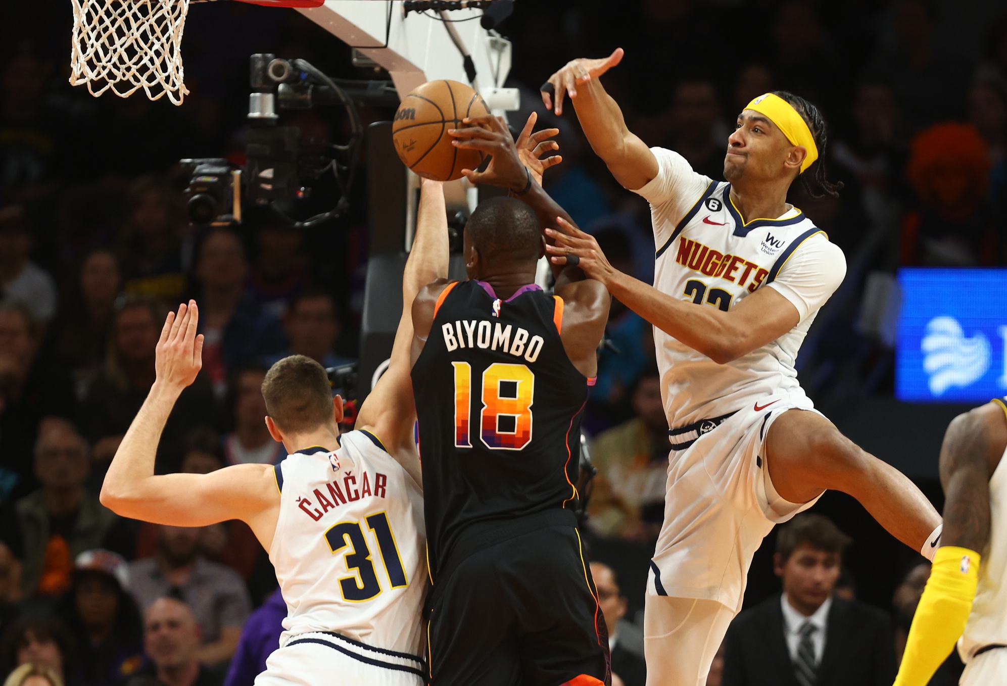 Apr 6, 2023; Phoenix, Arizona, USA; Phoenix Suns center Bismack Biyombo (18) drives to the basket under pressure from Denver Nuggets forward Zeke Nnaji (22) and Vlatko Cancar (31) in the second half at Footprint Center. Mandatory Credit: Mark J. Rebilas-USA TODAY Sports. Bismack is a potential target for the LA Lakers