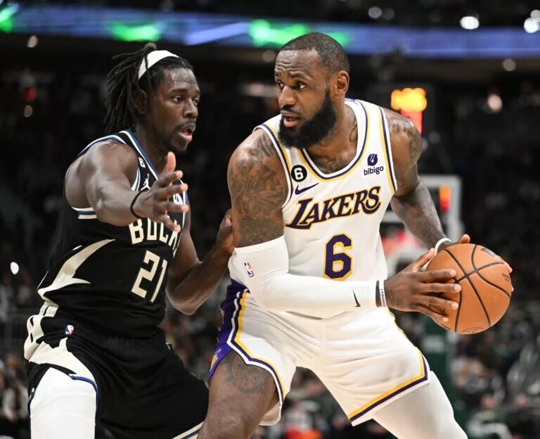 Dec 2, 2022; Milwaukee, Wisconsin, USA; Los Angeles Lakers forward LeBron James (6) posts up against Milwaukee Bucks guard Jrue Holiday (21) in the second quarter at Fiserv Forum. Mandatory Credit: Michael McLoone-USA TODAY Sports