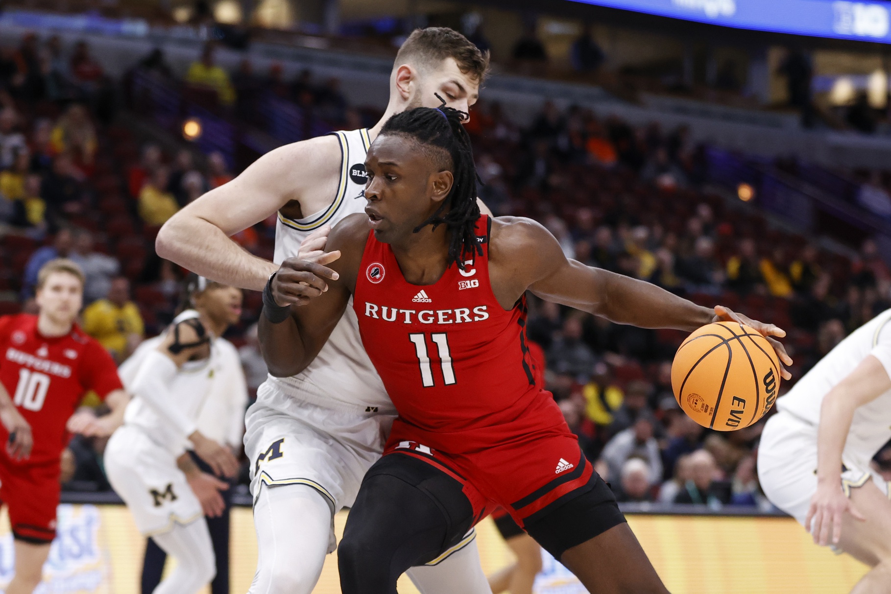 Mar 9, 2023; Chicago, IL, USA; Rutgers Scarlet Knights center Clifford Omoruyi (11) drives to the basket against Michigan Wolverines center Hunter Dickinson (1) during the first half at United Center. Mandatory Credit: Kamil Krzaczynski-USA TODAY Sports