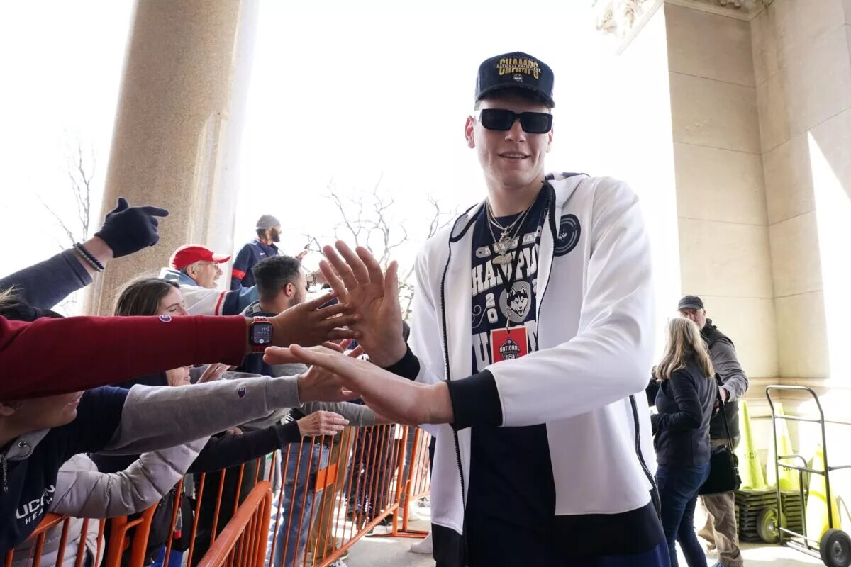 Apr 8, 2023; Hartford, CT, USA; UConn Huskies center Donovan Clingan (32) reacts with fans before the parade through downtown Hartford in their honor. Mandatory Credit: David Butler II-USA TODAY Sports