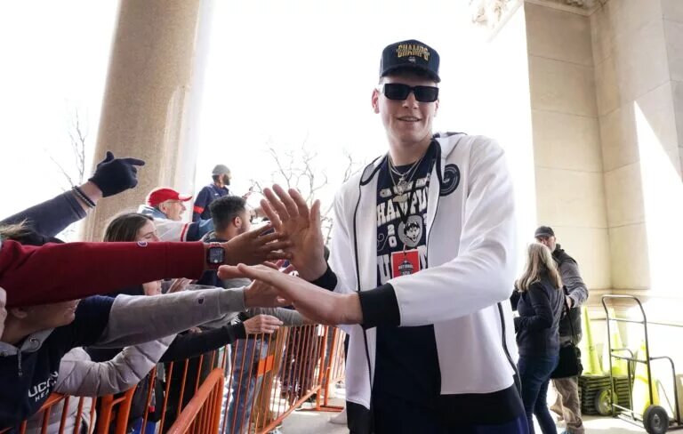 Apr 8, 2023; Hartford, CT, USA; UConn Huskies center Donovan Clingan (32) reacts with fans before the parade through downtown Hartford in their honor. Mandatory Credit: David Butler II-USA TODAY Sports
