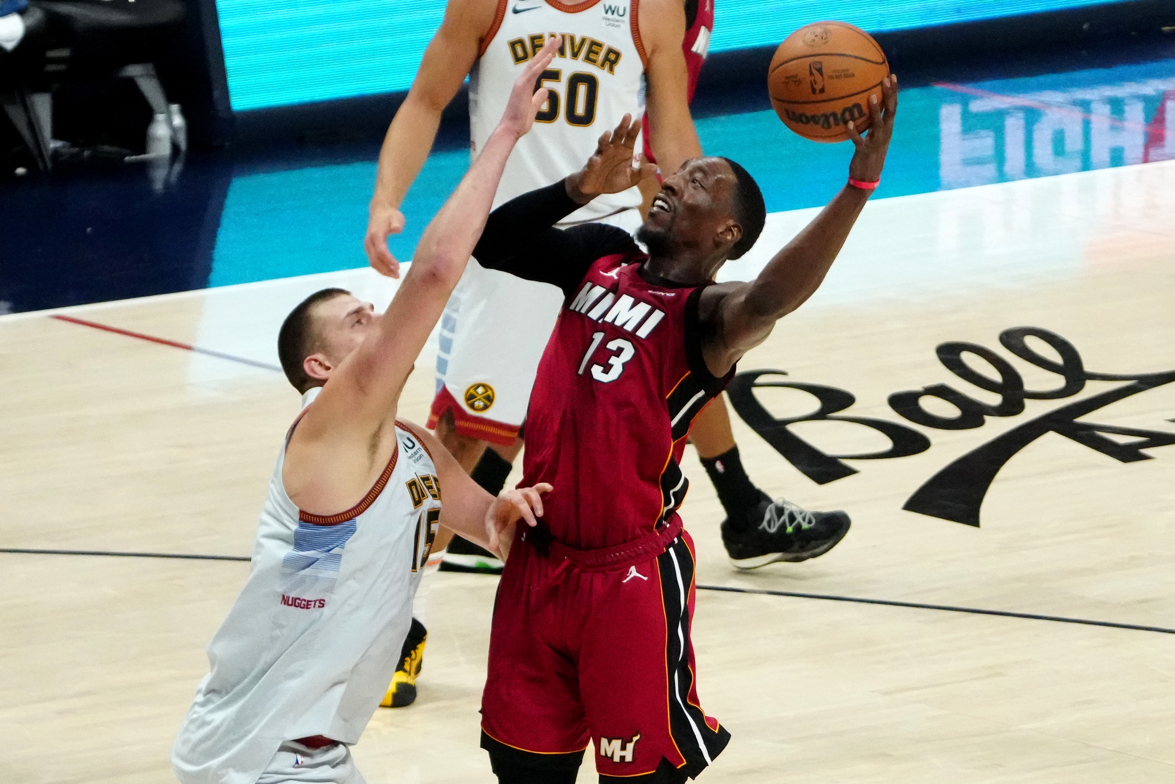 Jun 12, 2023; Denver, Colorado, USA; Miami Heat center Bam Adebayo (13) shoots against Denver Nuggets center Nikola Jokic (15) during the third quarter of game five of the 2023 NBA Finals at Ball Arena. Mandatory Credit: Ron Chenoy-USA TODAY Sports