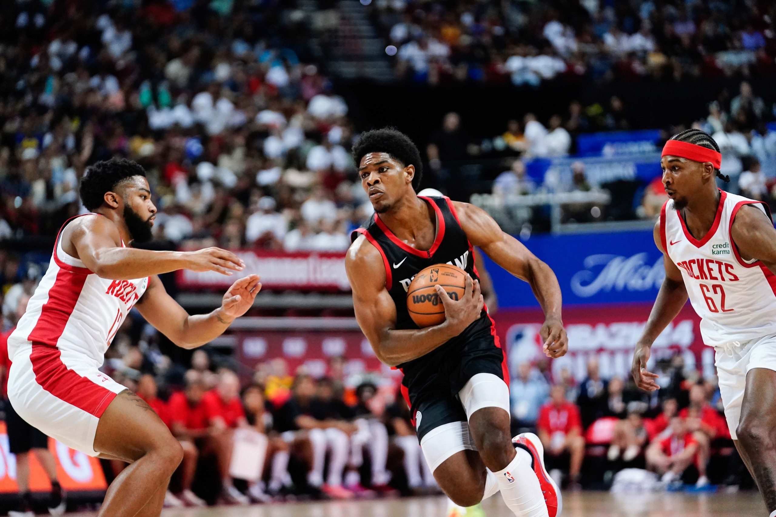 Jul 7, 2023; Las Vegas, NV, USA; Portland Trail Blazers guard Scoot Henderson (00) drives the ball against Houston Rockets guard Trevor Hudgins (12) and guard/forward Nate Hinton (62) during the first half at Thomas & Mack Center. Mandatory Credit: Lucas Peltier-USA TODAY Sports. He is a good asset for your fantasy basketball draft.