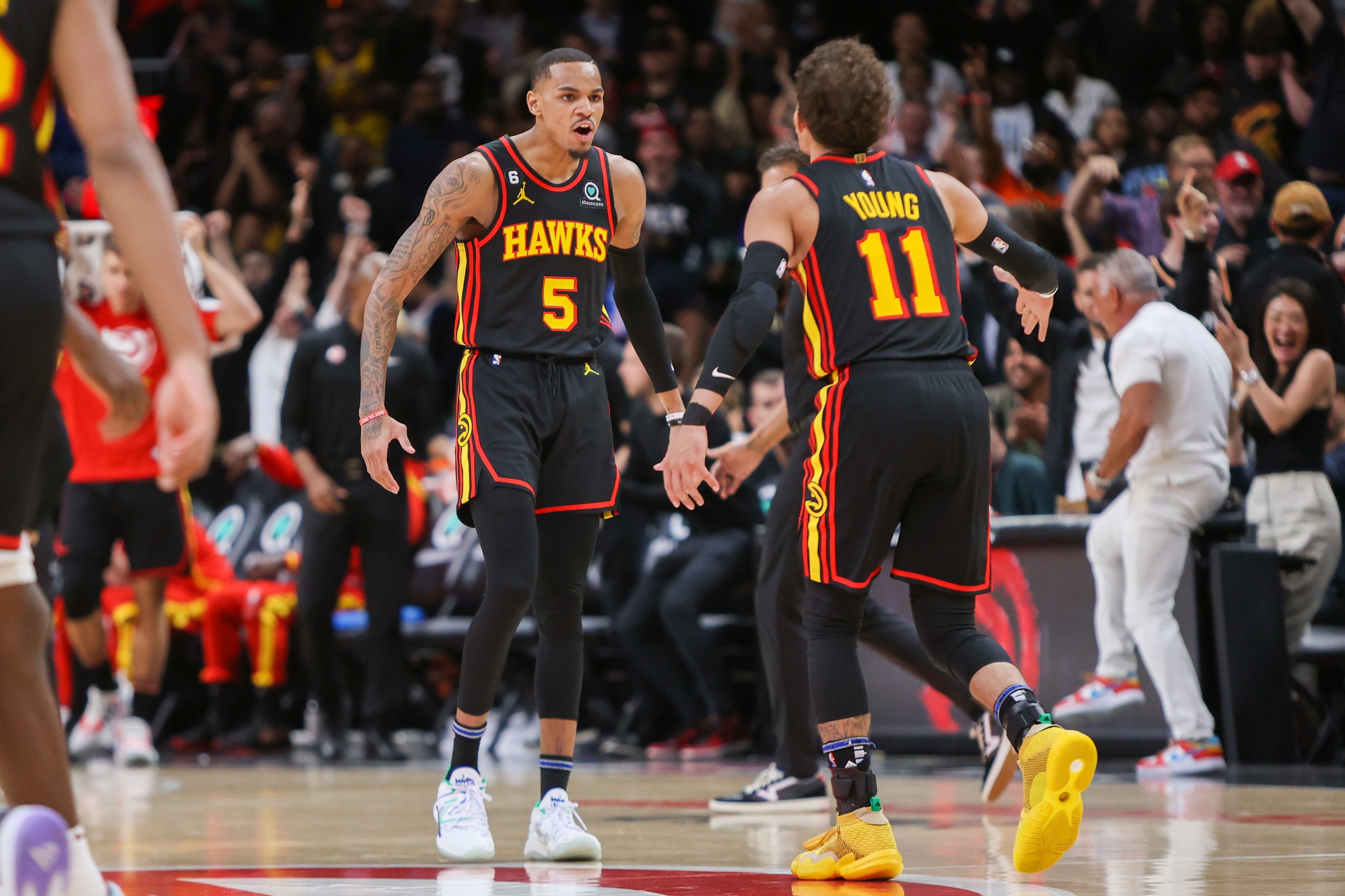 Mar 28, 2023; Atlanta, Georgia, USA; Atlanta Hawks guard Dejounte Murray (5) reacts with guard Trae Young (11) after a basket against the Cleveland Cavaliers in the second half at State Farm Arena. Mandatory Credit: Brett Davis-USA TODAY Sports