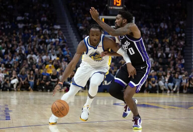 Oct 18, 2023; San Francisco, California, USA; Golden State Warriors forward Jonathan Kuminga (00) drives past Sacramento Kings guard Malik Monk (0) during the fourth quarter at Chase Center. Mandatory Credit: D. Ross Cameron-USA TODAY Sports