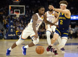 Oklahoma City Thunder guard Cason Wallace (22) drives past Golden State Warriors guard Brandin Podziemski (2) during the first quarter at Chase Center.