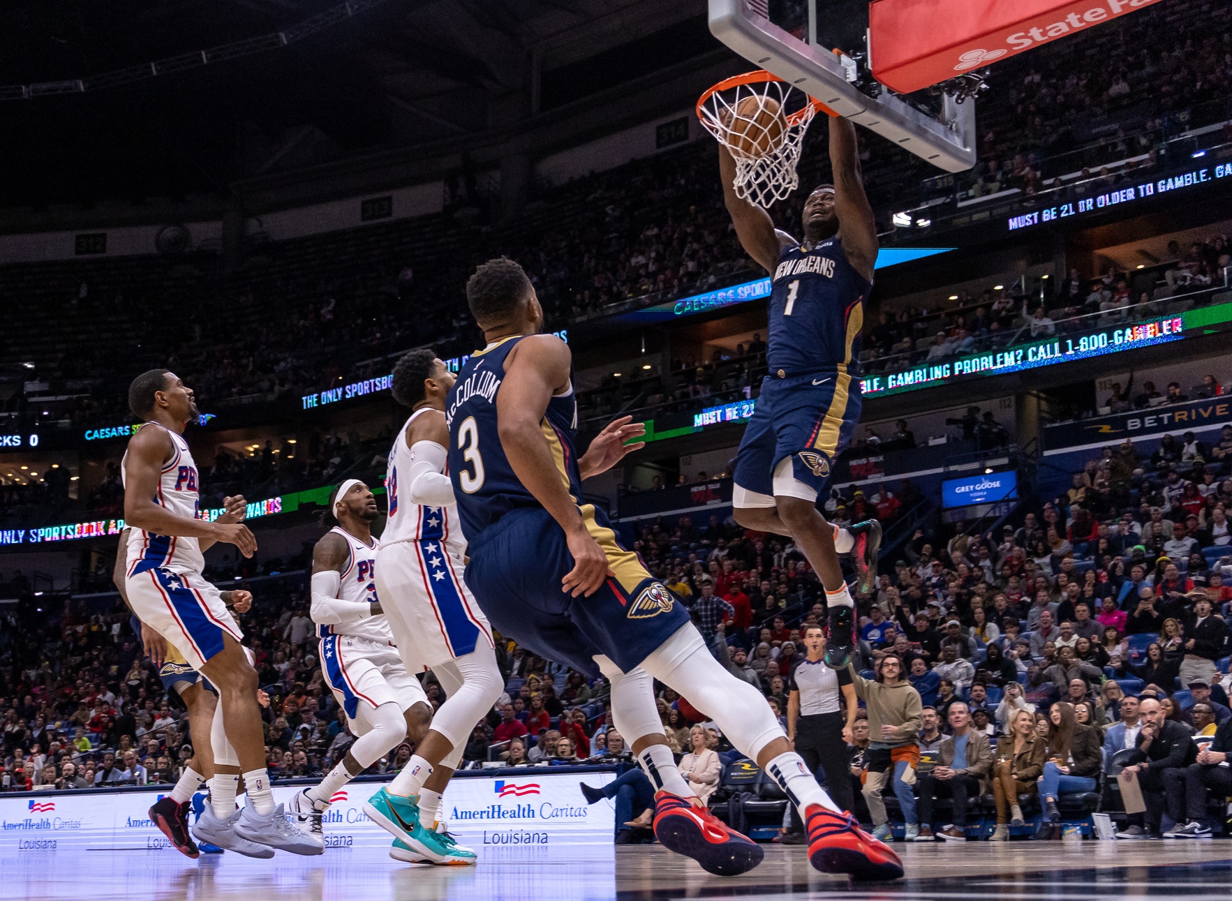 New Orleans Pelicans guard CJ McCollum (3) throws an alley-oop pass to forward Zion Williamson (1) for the dunk against Philadelphia 76ers forward Tobias Harris (12) during the second half at the Smoothie King Center.
