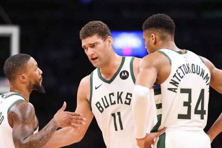 Milwaukee Bucks center Brook Lopez (11) talks to Milwaukee Bucks forward Giannis Antetokounmpo (34) and Milwaukee Bucks guard Damian Lillard (0) during the first half against the Boston Celtics at TD Garden.