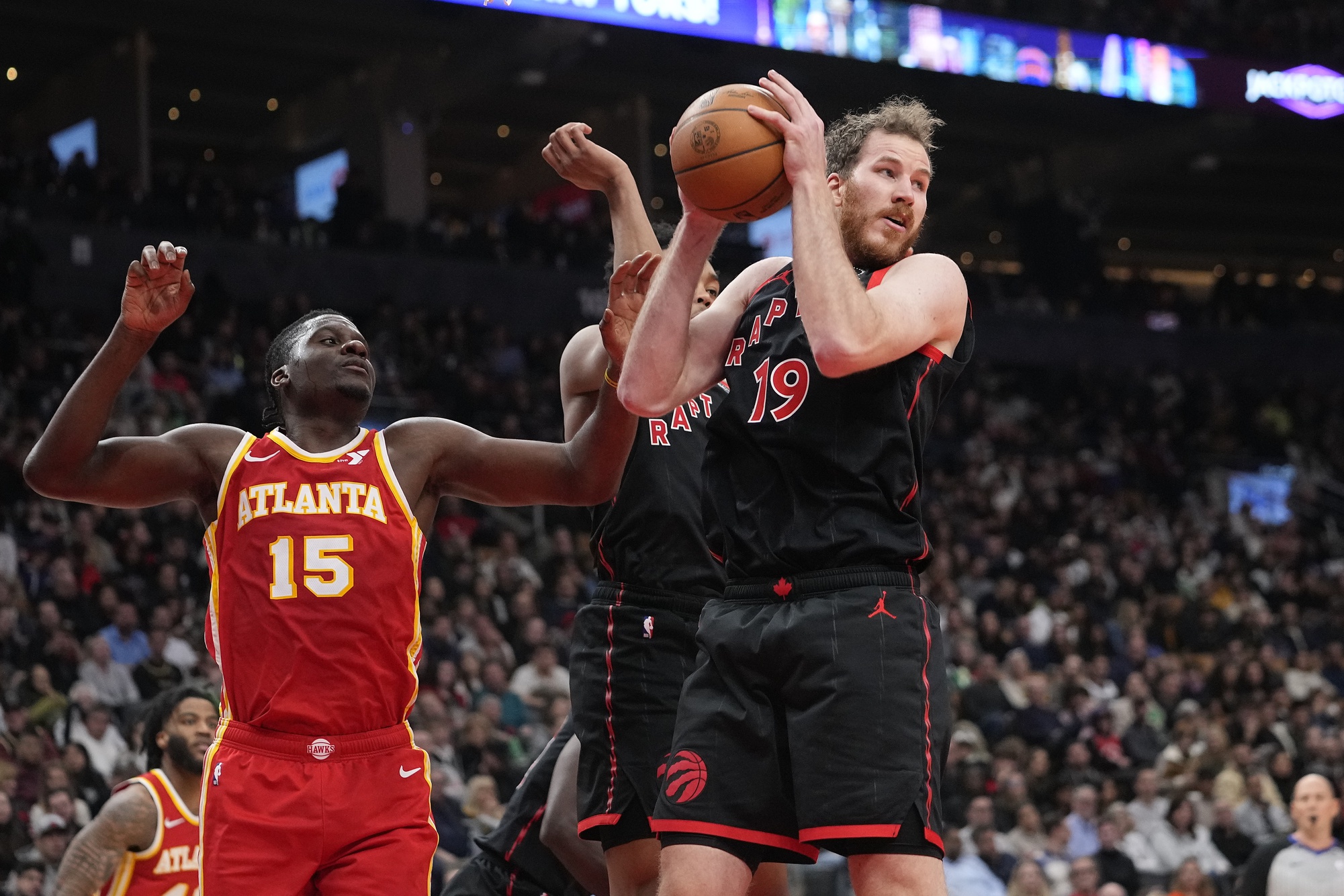 Dec 15, 2023; Toronto, Ontario, CAN; Toronto Raptors center Jakob Poeltl (19) comes down with a rebound against Atlanta Hawks center Clint Capela (15) during the first half at Scotiabank Arena. Mandatory Credit: John E. Sokolowski-USA TODAY Sports