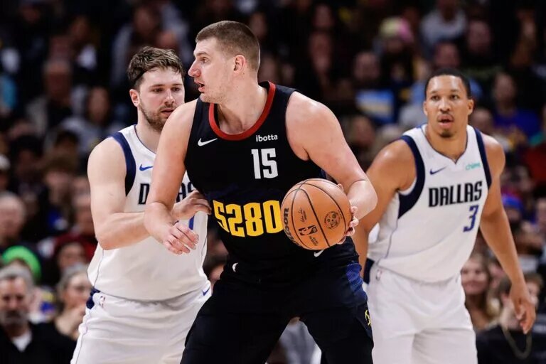 Dec 18, 2023; Denver, Colorado, USA; Denver Nuggets center Nikola Jokic (15) controls the ball as Dallas Mavericks guard Luka Doncic (77) guards in the third quarter at Ball Arena. Mandatory Credit: Isaiah J. Downing-USA TODAY Sports
