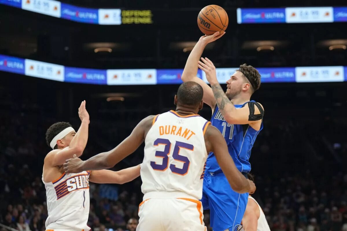 Dec 25, 2023; Phoenix, Arizona, USA; Dallas Mavericks guard Luka Doncic (77) shoots over Phoenix Suns guard Devin Booker (1) and Phoenix Suns forward Kevin Durant (35) during the second half at Footprint Center. Mandatory Credit: Joe Camporeale-USA TODAY Sports