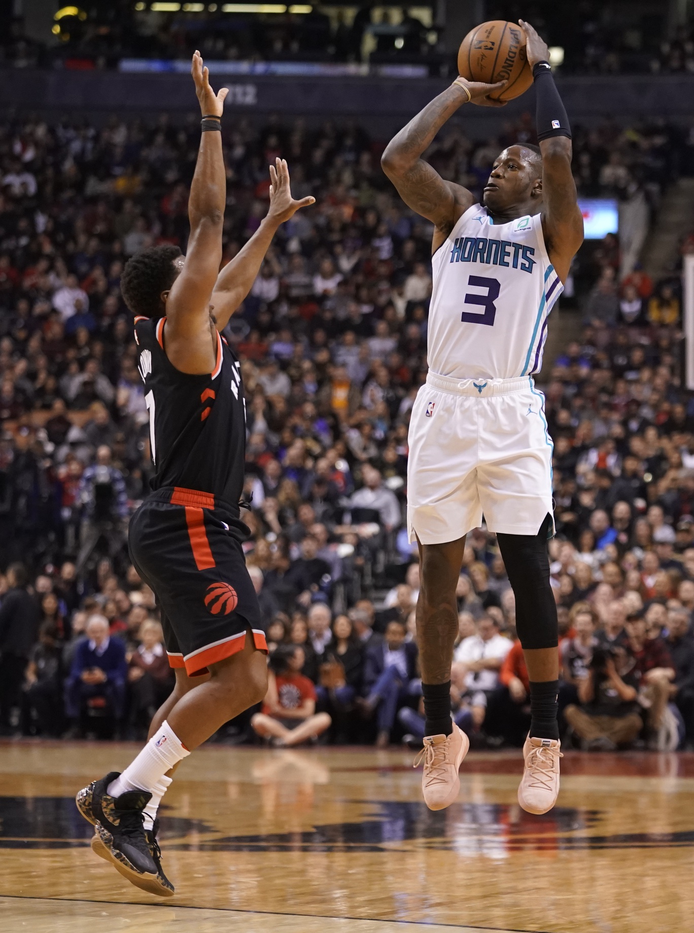 Charlotte Hornets guard Terry Rozier (3) makes a basket against Toronto Raptors guard Kyle Lowry (7) during the first half at Scotiabank Arena.