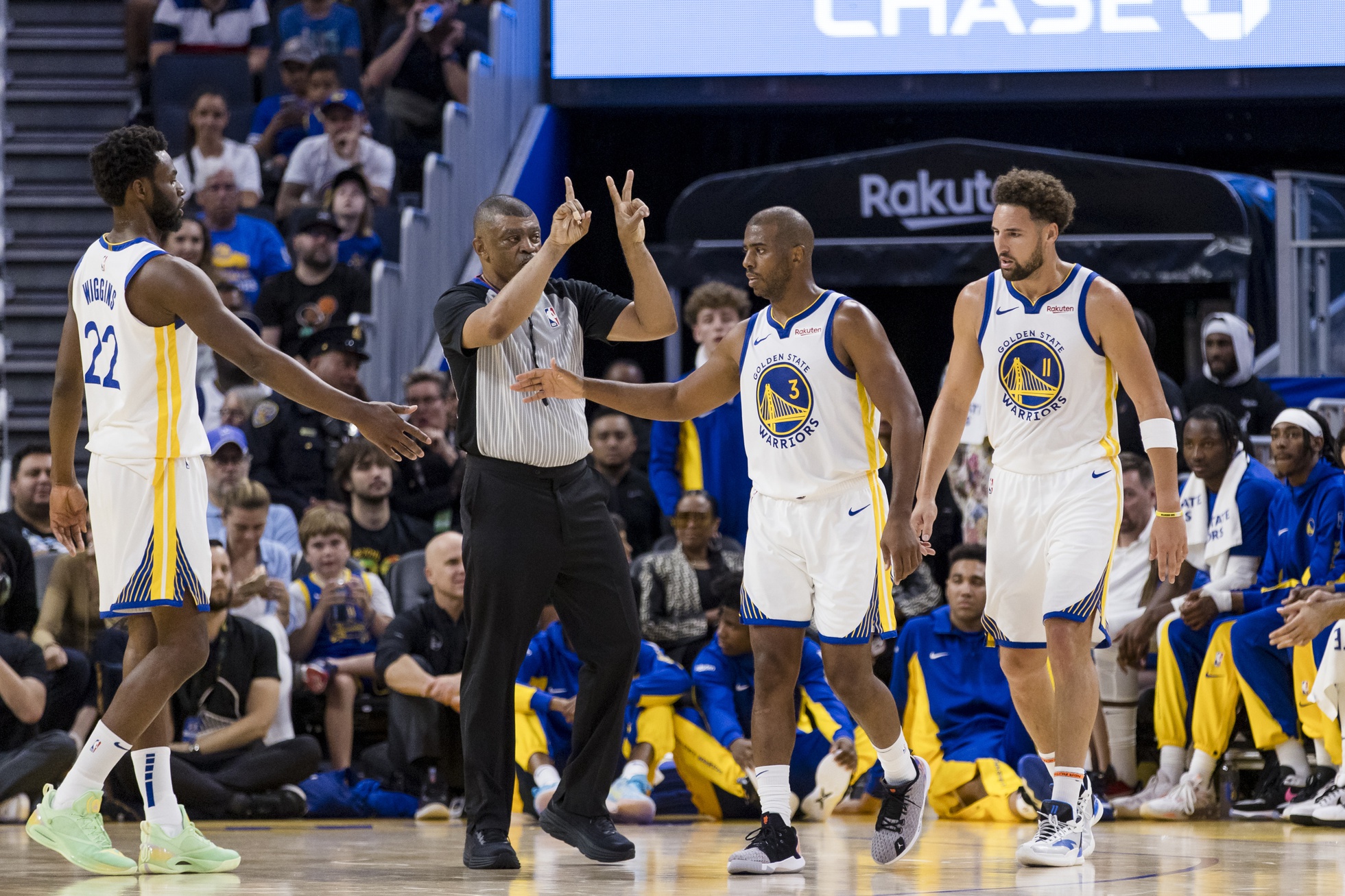 Golden State Warriors forward Andrew Wiggins (22) and guard Chris Paul (3) and guard Klay Thompson (11) reacts after a foul is called against the Los Angeles Lakers during the first half at Chase Center.