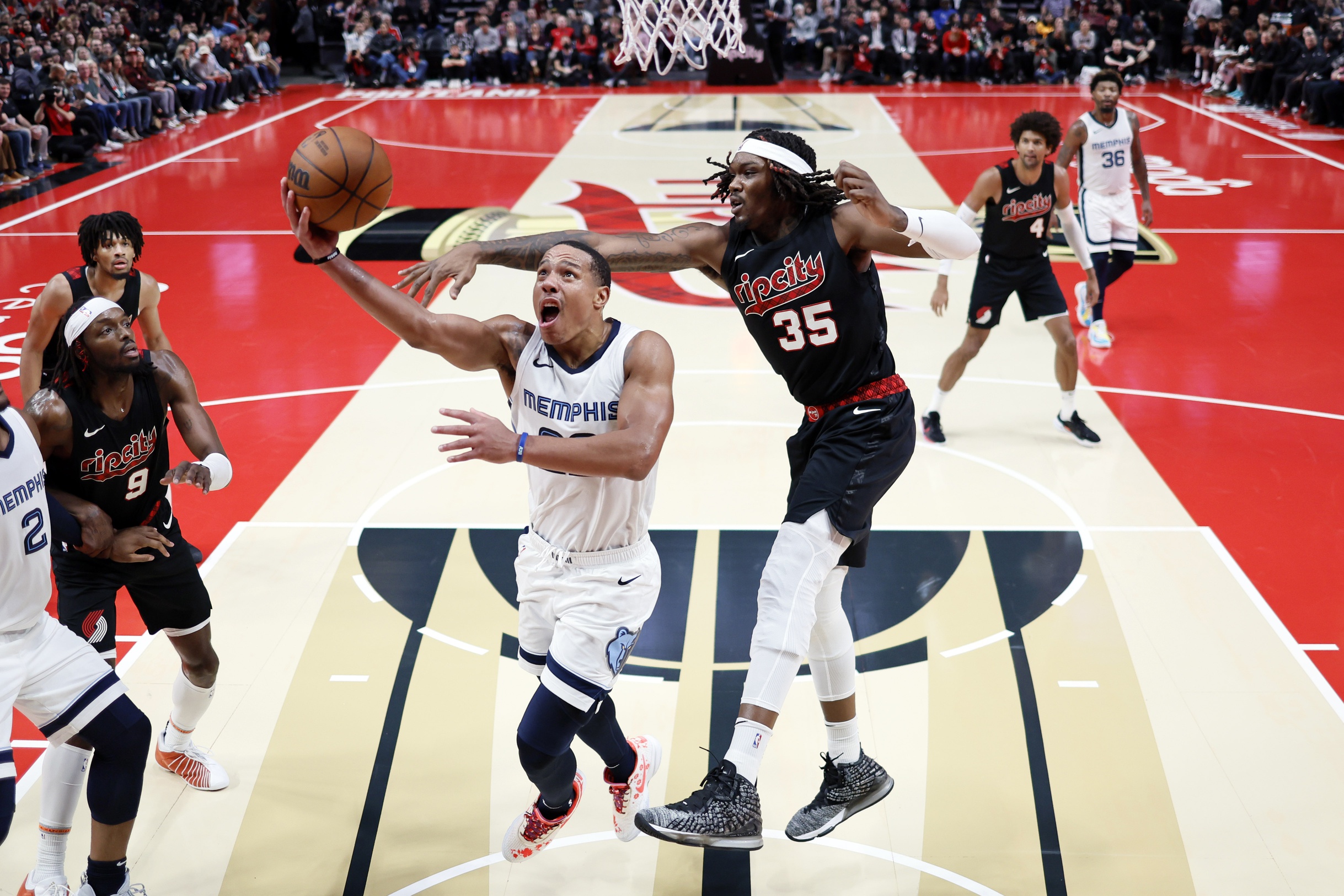 Memphis Grizzlies shooting guard Desmond Bane (22) drives to the basket under pressure from Portland Trail Blazers center Robert Williams III (35) during the second half at Moda Center.