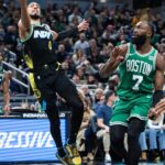 Indiana Pacers guard Tyrese Haliburton (0) shoots the ball against Boston Celtics guard Jaylen Brown (7) in the second half at Gainbridge Fieldhouse.