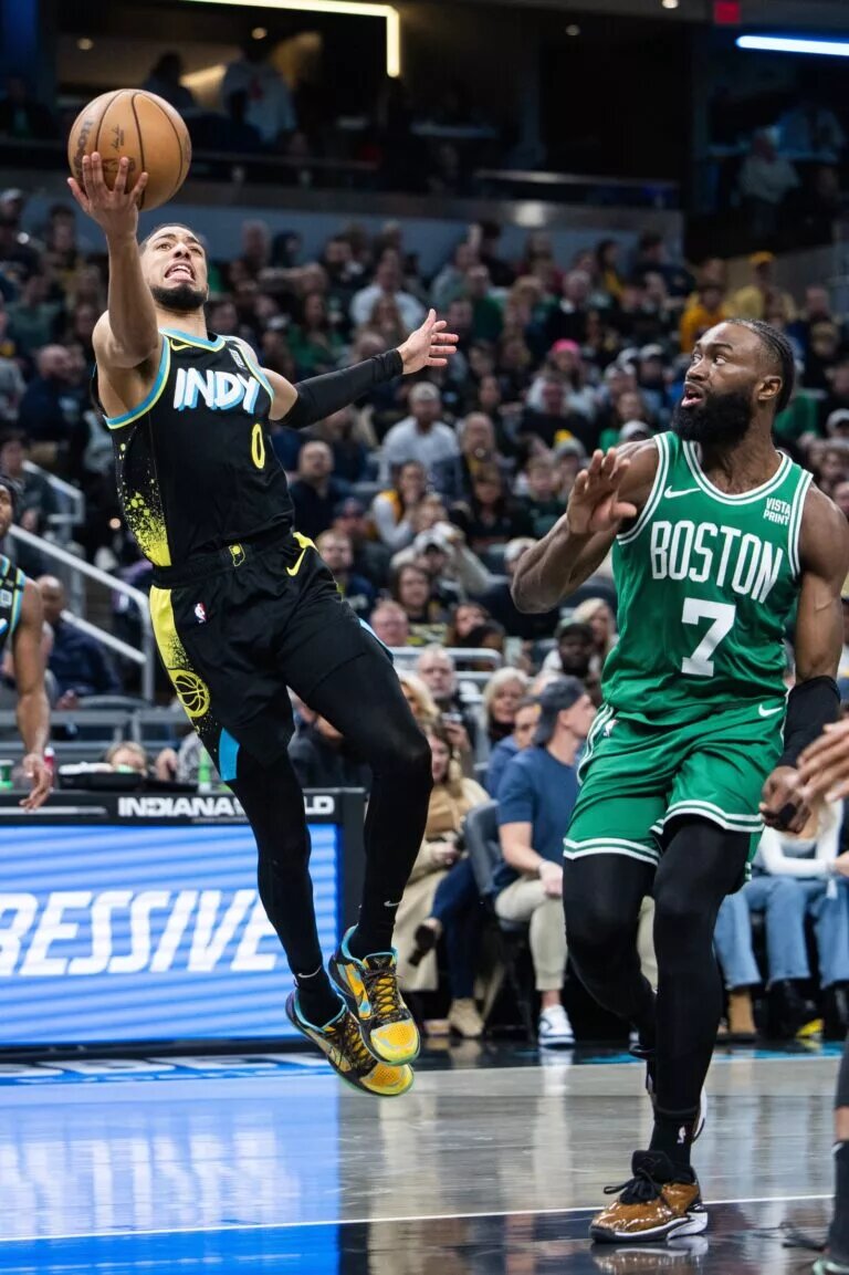 Indiana Pacers guard Tyrese Haliburton (0) shoots the ball against Boston Celtics guard Jaylen Brown (7) in the second half at Gainbridge Fieldhouse.